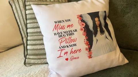 Photograph of a teenage girl with wings imprinted on a pillow sitting on a couch 