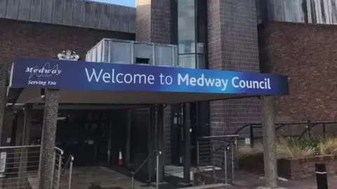 Exterior of Medway Council offices with a big blue "Welcome to Medway Council" sign above the entrance 