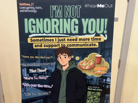 Poster of a boy with brown hair, wearing a black and green hoodie jacket. There is a graphic of salad, a roll and a red cup with a straw to the right. The main headline on the poster is in green and says I'm Not Ignoring You! 