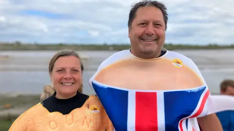 Lewis Adams/BBC Andy Munday, the Mayor of Halstead, wearing a tea cup costume, with Linda Smith, dressed in a biscuit costume.