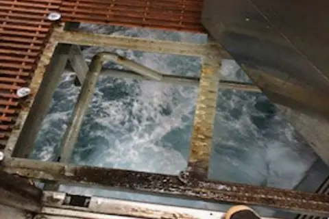 COPFS A gap in North Sea rig grating which shows the sea below.