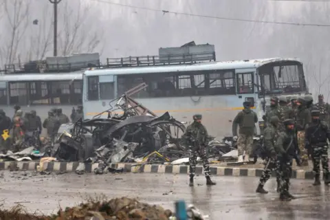 Pasukan Keamanan Getty Images di dekat kendaraan yang rusak di Lethpora di Jammu-Srinagar Highway, pada 14 Februari 2019 di Srinagar, India