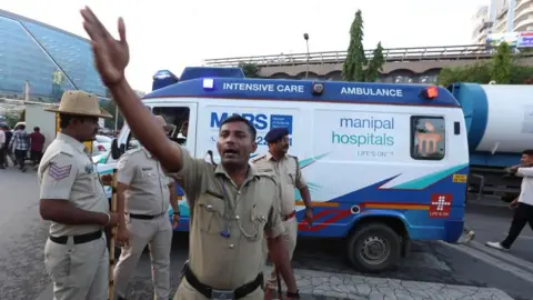 An ambulance transports stampede victims near Chinnaswamy Stadium in Bengaluru