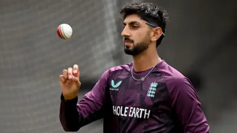 Shoaib Bashir flicks the ball in the air while training with England