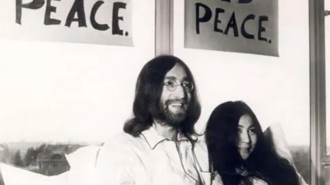 PA Media John Lennon and Yoko Ono pictured in bed in 1969 