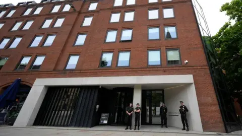 Police officers outside No 10 North, located in Heron House, central Manchester.