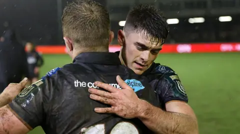 Ospreys scrum-half Reuben Morgan-Williams and Keiran Williams embrace