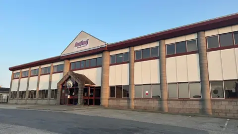 a building with a red and blue logo on the front which reads Scotbeef Inverurie