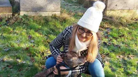 A family handout photo of Izabela Chalastra cuddling a dog.