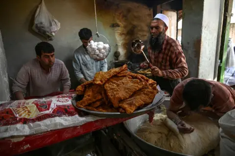 Wakil Kohsar / AFP Workers prepare bolani at a roadside stall