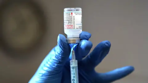 A health worker holds a Covid vaccine