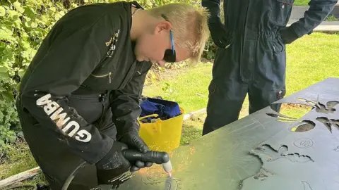 Felix Rowberry A boy using a plasma cutter to cut out a shape from a metal sheet