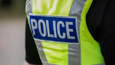 A close up of a generic police stab vest, with 'Police' in hi vis lettering across the back.