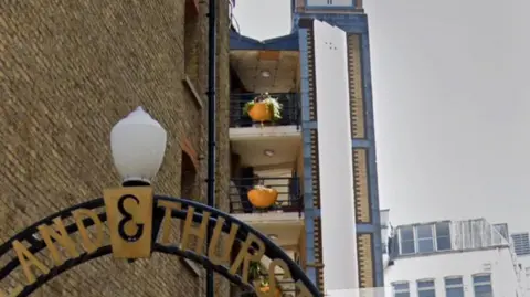 Google The top floor balcony with the original blue railing, and attached orange planter can be seen on Google street view