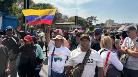 protesters in Caracas waving the Venezuelan flag protesting in support of former president Nicolás Maduro