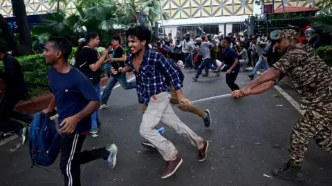 Reuters A security force personnel wields his baton against demonstrators at a protest site during a planned march by supporters of India's Cockroach Janta Party