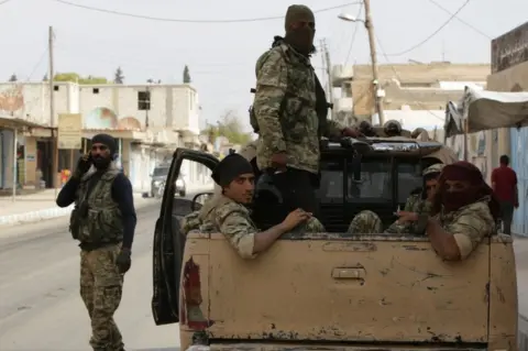 AFP/Getty Images Turkish-backed Syrian fighters sit in the back of a truck in the Syrian border town of Tal Abyad on October 17, 2019
