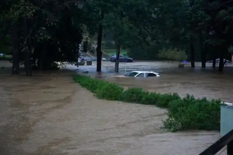 Megan Varner/Getty Images A car is submerged in floodwaters in the Buckhead area of ​​Atlanta, Georgia