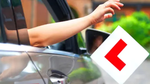 Getty Images Driver throwing L plates out of a car window