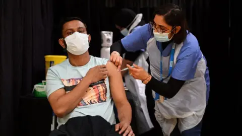 Getty Images A health worker gives someone a vaccine in London