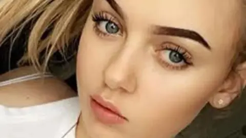 Facebook A young white girl with thick brown manicured eyebrows, blonde hair and blue eyes, stares at the camera