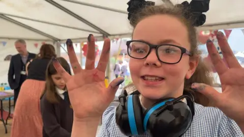 Andrew Turner/BBC Sophia holding up her paint-covered hands