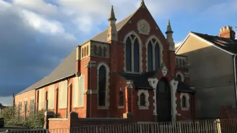 A general view of the Methodist church, with wooden boards covering at least four windows on its left side