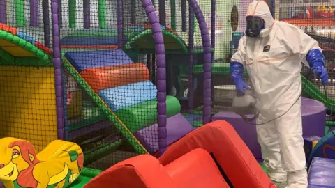 DJ Jungles A person in PPE cleaning equipment