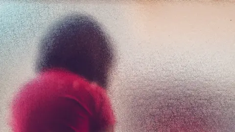 Getty Images Person behind window