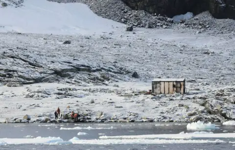 UKAHT A small hut on Blaiklock Island in Antarctica, alone in a snowy and barren landscape. 