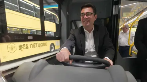 PA Media Greater Manchester mayor Andy Burnham views the 'Bee Network' buses at manufacturer Alexander Dennis in Larbert, Falkirk.