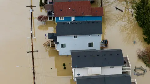 Reuters A drone view shows homes in an area flooded by the Snohomish River, as an atmospheric river brings rain and flooding to the Pacific Northwest, in Snohomish, Washington, U.S., December 11, 2025.