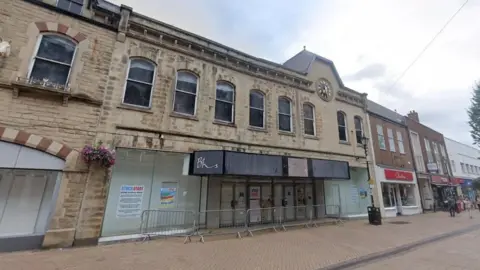 Google A large stone clad building along a red-brick high street. The BHS signage can be seem from the front.