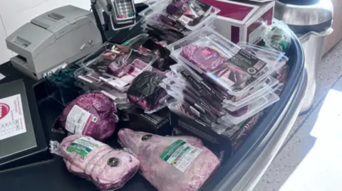 Cambridgeshire Police A large amount of packaged meat at the check-out station on a till. 