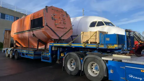 Lifeboat and plane being delivered at school