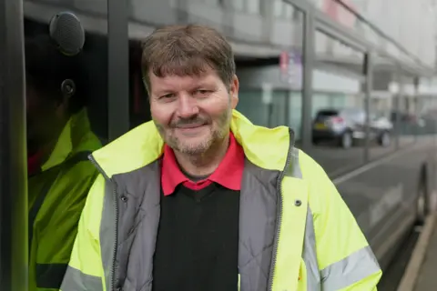 BBC/Andy Alcroft Andy Collett wearing a hi-vis vest, looking down the camera. 