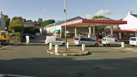 Google The roundabout as seen from the direction of Summerhill Road. There are cars travelling through the junction and the petrol station is in the background.