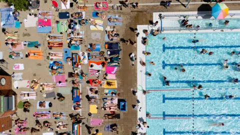 EPA/Shutterstock People sunbathing in lido
