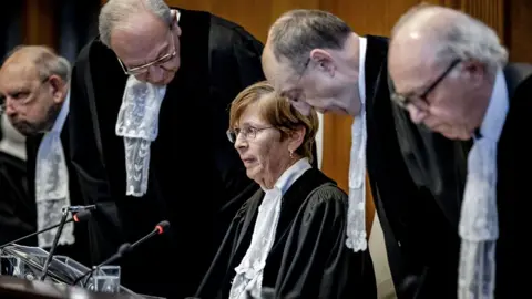 Getty Images ICJ president Joan Donoghue (C) and other ICJ judges at the International Court of Justice wearing white shirts and black gowns  