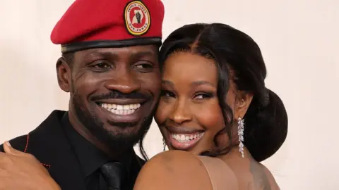 ALIAH ANDERSON/GETTY IMAGES Bobi Wine and Barbie Kyagulanyi smile and embrace.