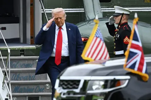 Leon Neal/PA Wire President Donald Trump salutes as he arrives by helicopter at Chequers, the country home of the British prime minister, on September 18, 2025 in Aylesbury, England. 