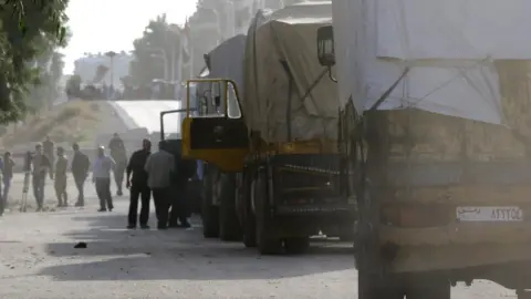 Getty Images UNHCR aid convoys prepare to enter Moadimayet al-Sham, a rebel-held town near the Syrian capital Damascus.