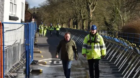 PA Media Environment Secretary George Eustice is accompanied by a member of the Environment Agency