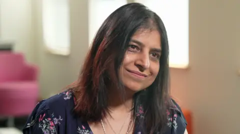 BBC Susan Kohli wearing a navy flowery top.