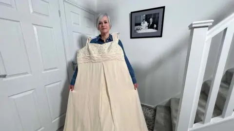 Steve Hubbard/BBC Jenny Evett at her home in Milton Keynes with her size 28 wedding dress