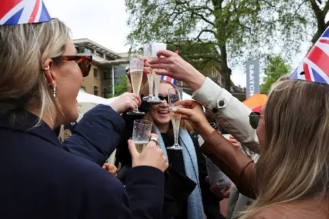 Reuters People take part in celebrations following Britain's King Charles and Queen Camilla's coronation