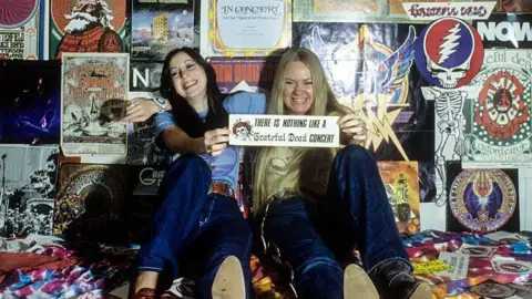 Getty Images Deadheads pose in front of Grateful Dead posters in a Haight Ashbury apartment in January 1980 in San Francisco, California.