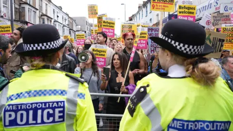 Demonstrators and constabulary  officers astatine  an anti-racism protestation  successful  Walthamstow, London