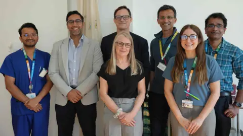 Alder Hey Children’s Foundation Trust 5 men and 2 women stand smiling to the camera. 