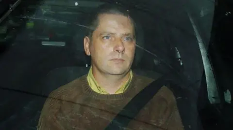 PA Media reporter Martin McCauley drives away from a police station in Dublin